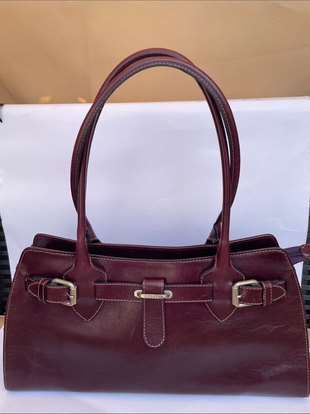 Prüne vintage bag features genuine leather in a prune or brown color
